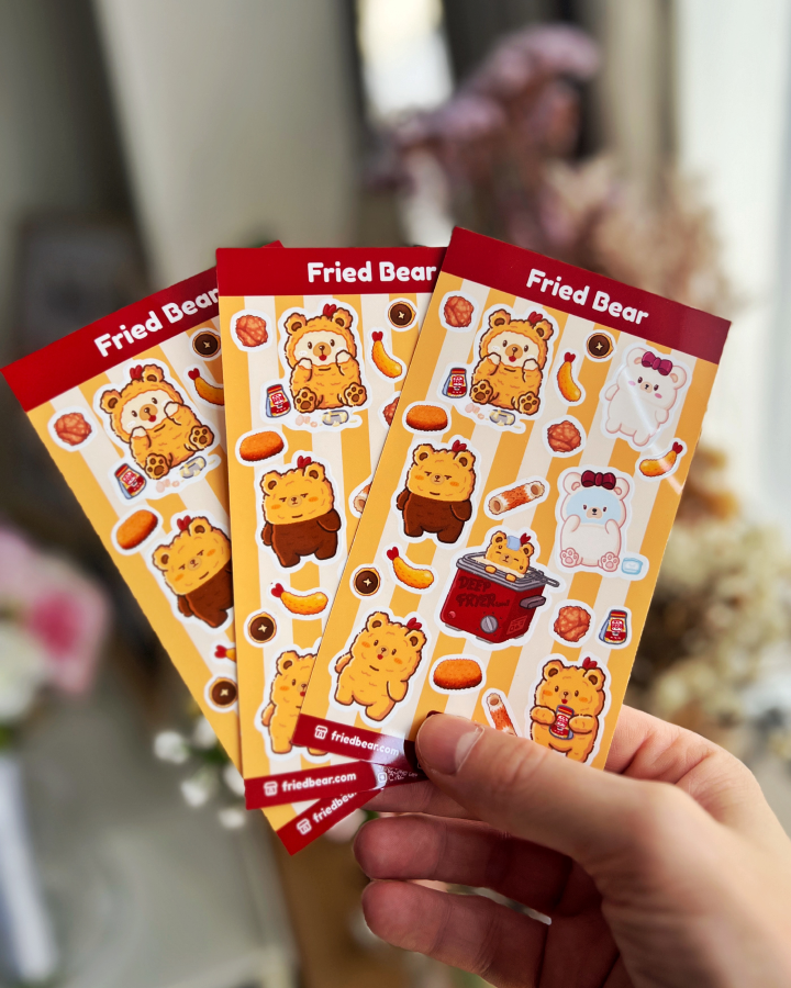 Three Fried Bear sticker sheets with Fried Bear, Tofu Bear and fried foods fanned out in a hand