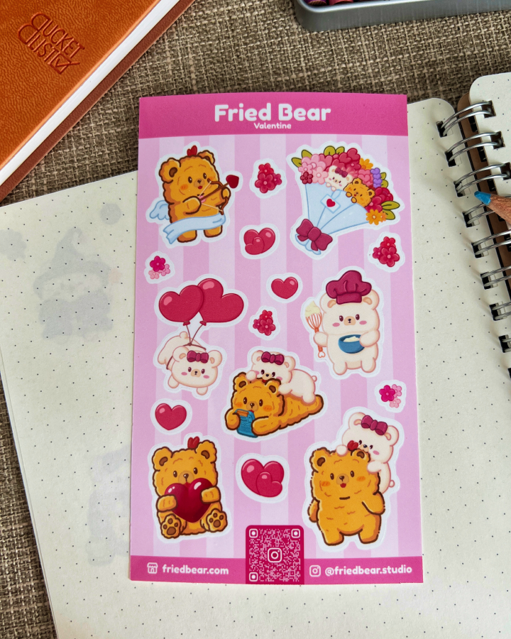 Fried Bear Valentine sticker sheet with hearts, balloons and a bouquet lying on a dotted notebook